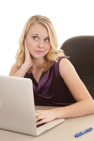 A woman working on her computer but daydreaming.の写真素材