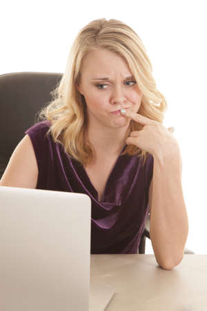 A woman with her finger up to her lip thinking and not sure what is going on.の写真素材