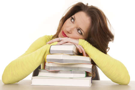 A woman is laying on a stack of books.の写真素材