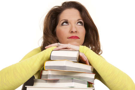 A woman is laying on a stack of books.