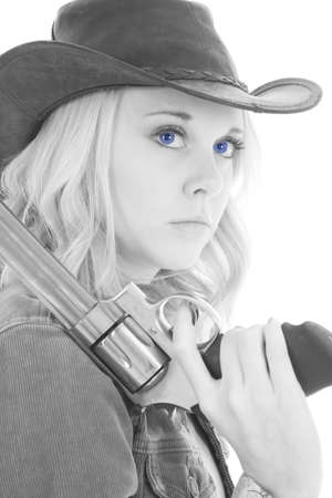 a black and white photo of a cowgirl holding on to her pistol with a serious expression on her face.の写真素材