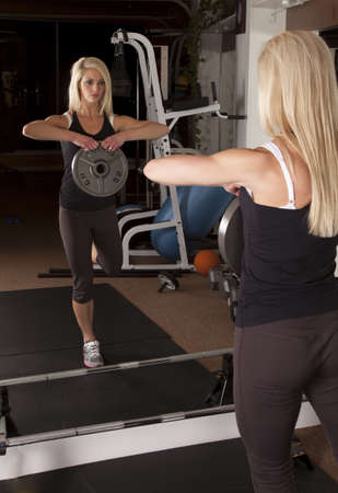A woman lifting a weight showing off her strength and balance.の写真素材