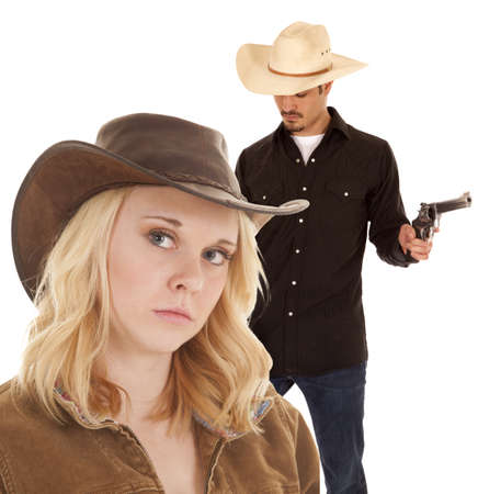 A cowboy is holding two guns and looking down.の写真素材