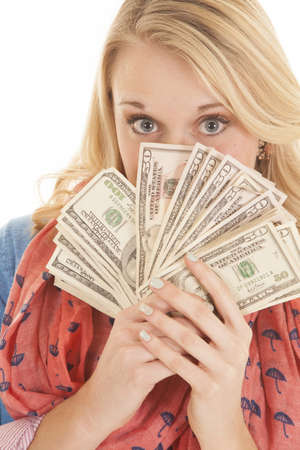A woman with her eyes peeking over her money.の写真素材