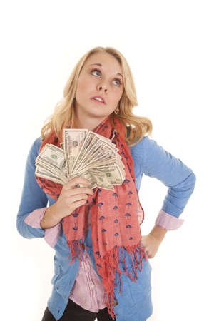 A woman holding on to a fan of lots of money looking up,の写真素材