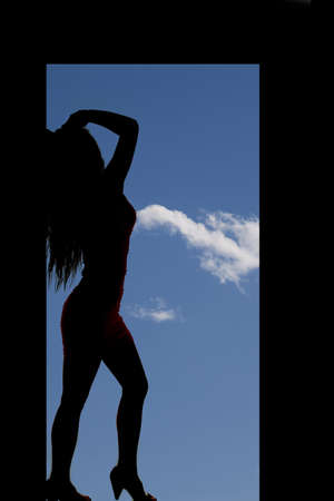 A silhouette of a woman standing in a door frame.の写真素材