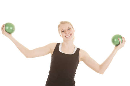 a woman with a big smile on her lips holding out her weighted balls.の写真素材