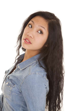 a close up of a woman looking away over her shoulder in her denim topの写真素材