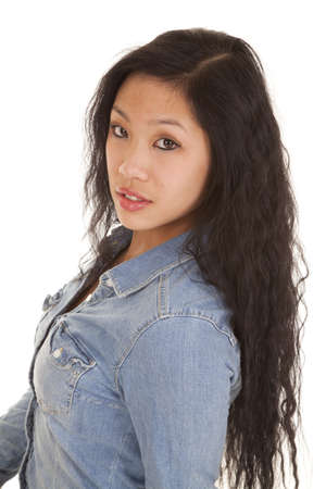 a woman looking at the camera with her dark hair and small smile on her lips.の写真素材
