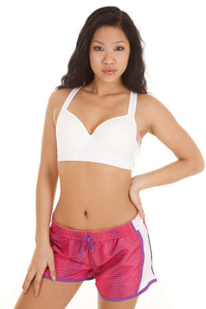a woman with a serious expression on her face in her sports bra and workout shorts.の写真素材