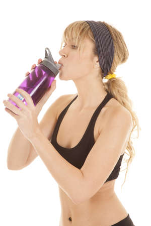 A woman taking a drink of her water bottle after a hard workout.の写真素材