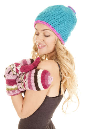 a woman with a smile on her face enjoying the warmth from her hat and gloves.の写真素材
