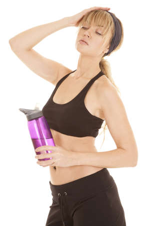A woman with her hand on top of her head holding on to her water bottle.の写真素材