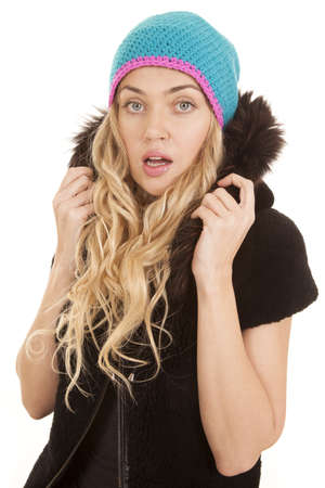 a woman with a shocked expression on her face holding on to her furry hood.の写真素材