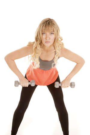 a woman with a serious expression on her face lifting her weights.の写真素材