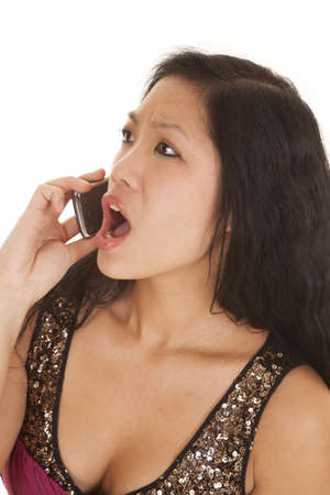 A woman not happy with the conversation that she is having on the phone.の写真素材