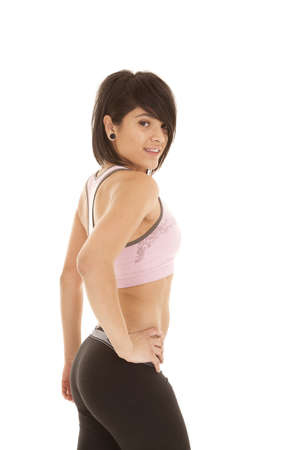 A woman with a smile on her face after working out with her hand on her hip.の写真素材