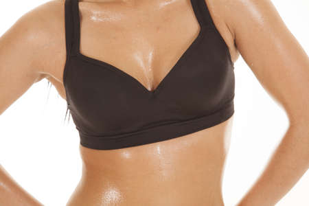 A close up of a woman's chest and stomach with sweat dripping off of it.の写真素材