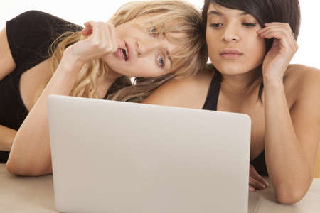 Two women looking at a laptop with serious expressions.の写真素材