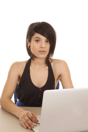 A woman sitting at a desk  working on her laptop.の写真素材