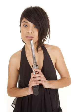 A woman in her black sheer shirt holding a pistol by her lips の写真素材