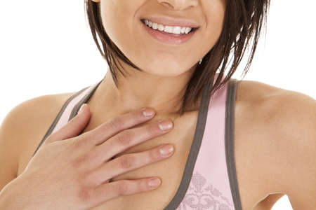 a woma with a smile on her lips and her hand on her chest.の写真素材