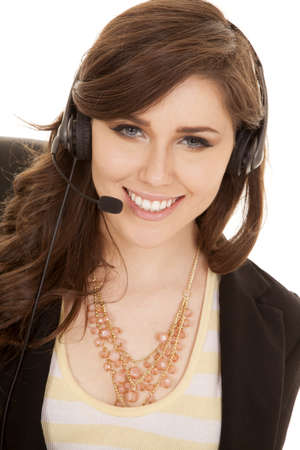 A woman working with her headset on with a smile on her lips.の写真素材
