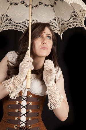 A woman hiding under her umbrella in her western vintage clothes.の写真素材