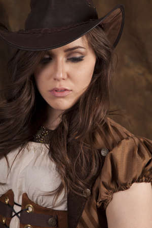 A close up of a woman looking down in her vintage clothing and cowgirl hat.の写真素材