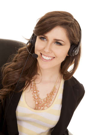 A woman working with her headset on with a smile on her lips.の写真素材