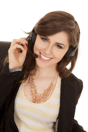 A woman working with her headset on with a smile on her lips.の写真素材
