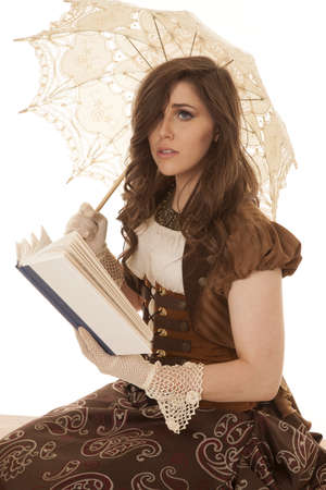 A woman in her vintage clothing reading a sad story holding on to her umbrellaの写真素材