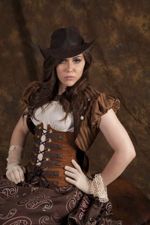 A woman in her vintage western dress and hat with a serious expression on her face.の写真素材