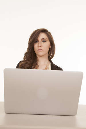 A woman working on her laptop with a serious expression on her face.の写真素材