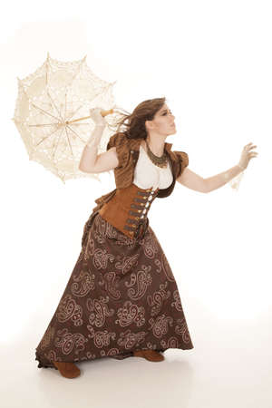 A woman trying to walk in the wind while holding on to her umbrella.の写真素材