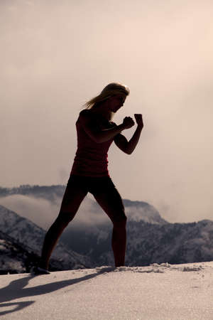 A silhouette of a woman working out boxing.の写真素材