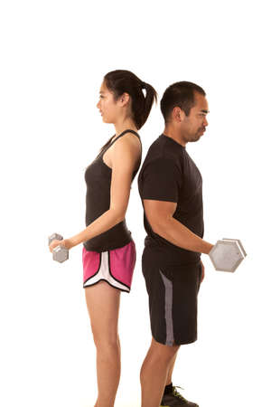 A man and a woman working out with weights back to backの写真素材