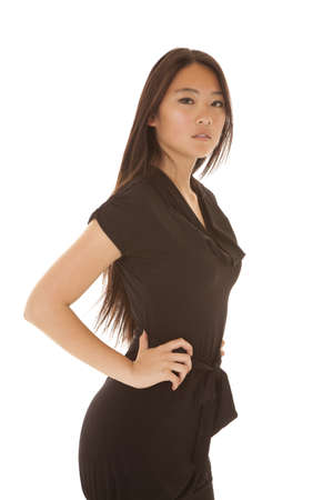 A woman looking at the camera with a serious expression on her face and her hands on her hips.の写真素材