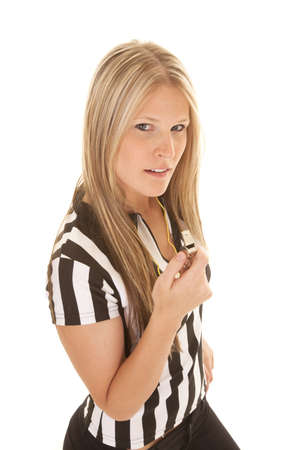 A woman in her referee top holding on to her whistle looking at the cameraの写真素材