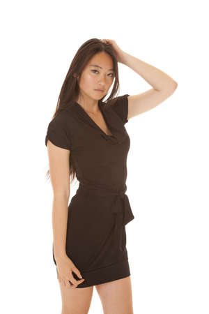 A woman with her hand in her hair with a serious expressionの写真素材