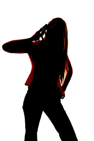 Silhouette of a woman holding a cell phone by her ear.の写真素材
