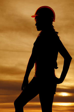 a silhouette of a woman wearing her construction hat.の写真素材