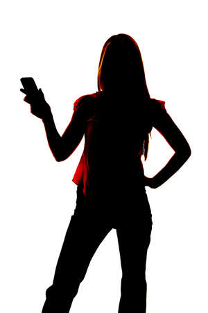 Silhouette of a woman holding out a cell phone.の写真素材