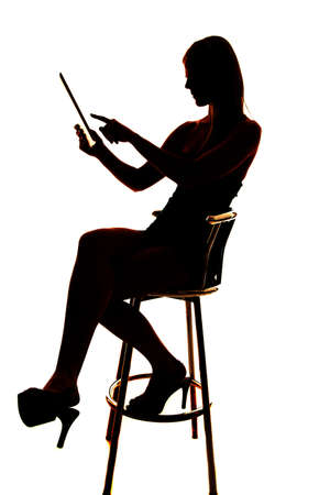 Silhouette of a woman using a tablet pointing.の写真素材
