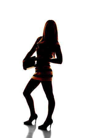 A silhouette of a woman holding on to a stack of books.の写真素材