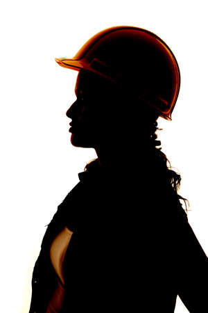 A close up silhouette of a woman's face and hard hatの写真素材