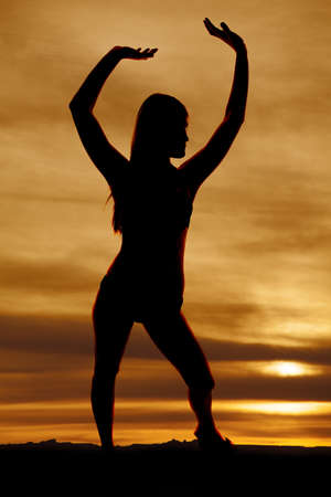 A silhouette of a woman in a swimsuit in the sunset.の写真素材