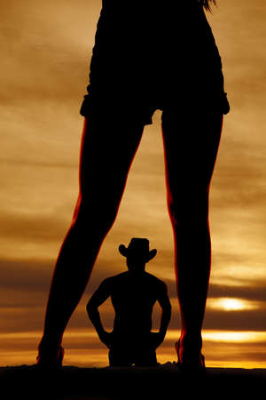 a silhouette of a cowboy in the middle of woman's legs.の写真素材