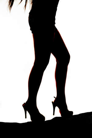 A silhouette of a woman walking up a hill.の写真素材