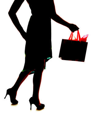 a silhouette of a woman holding on to her shopping bagの写真素材